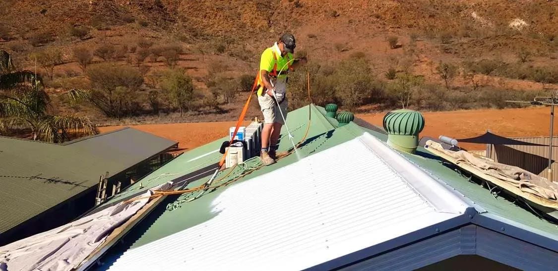A Man is Standing on the Roof of a House  — NHM Painting & Projects Pty Ltd in Ciccone, NT