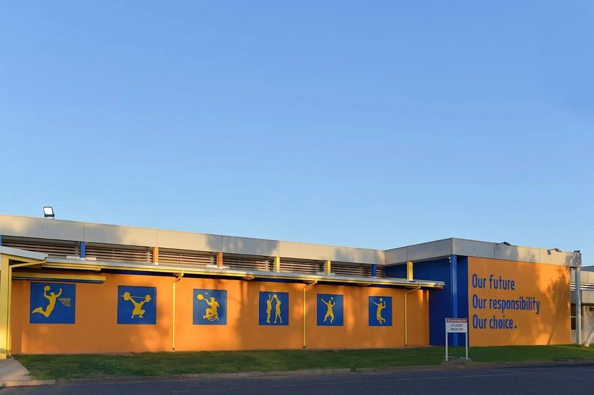 A Yellow and Blue Building With a Sign That Says Do Nothing — NHM Painting & Projects Pty Ltd in Ciccone, NT