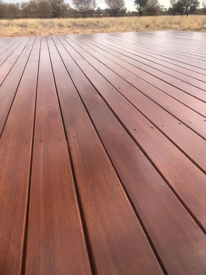 A Close Up of a Wooden Deck With a Field in the Background  — NHM Painting & Projects Pty Ltd in Ciccone, NT
