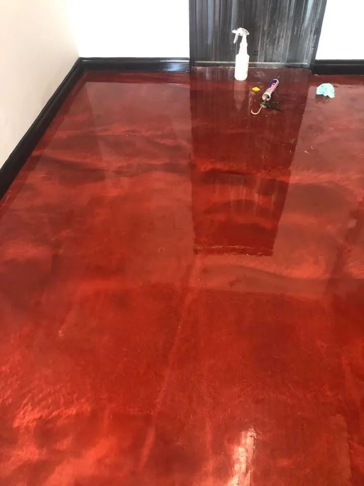 A Red Metallic Floor With a Spray Bottle and Keys on It  — NHM Painting & Projects Pty Ltd in Ciccone, NT