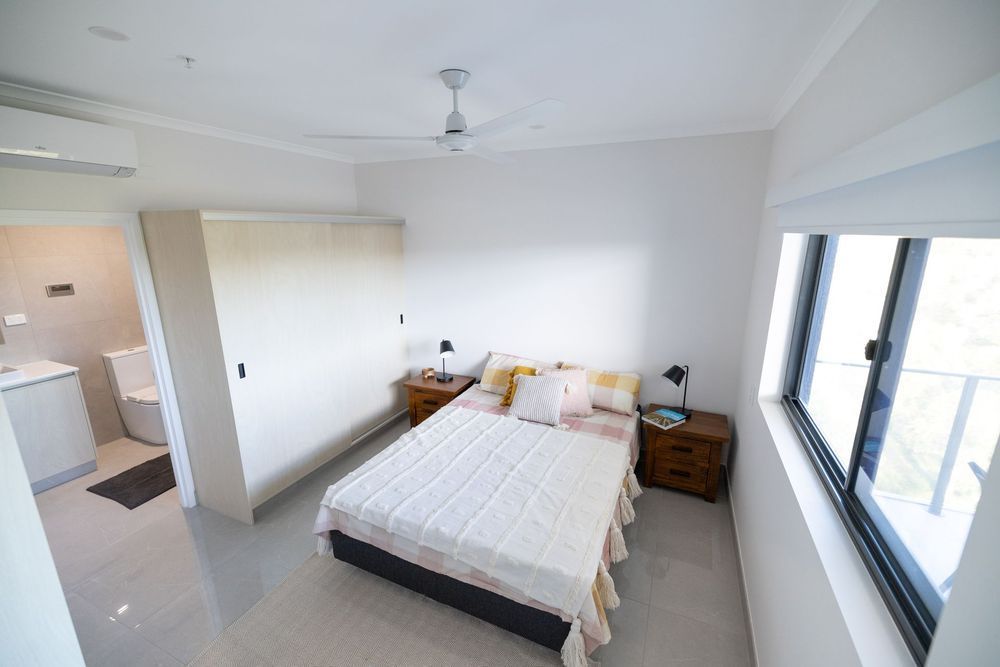 A Bedroom With a Bed, Nightstands, and a Ceiling Fan — NHM Painting & Projects Pty Ltd in Ciccone, NT