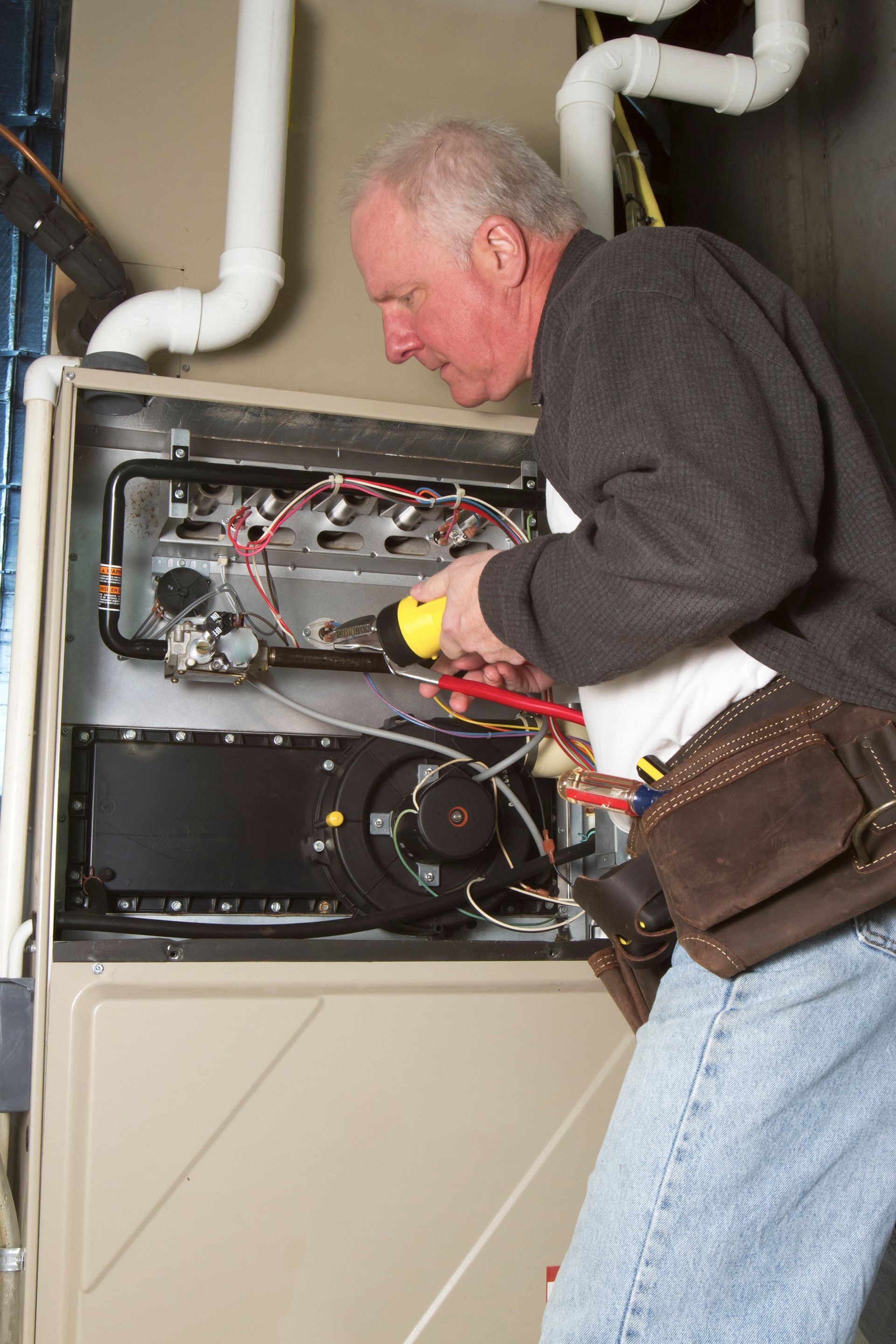 Skilled technician repairing basement furnace system to restore warmth.