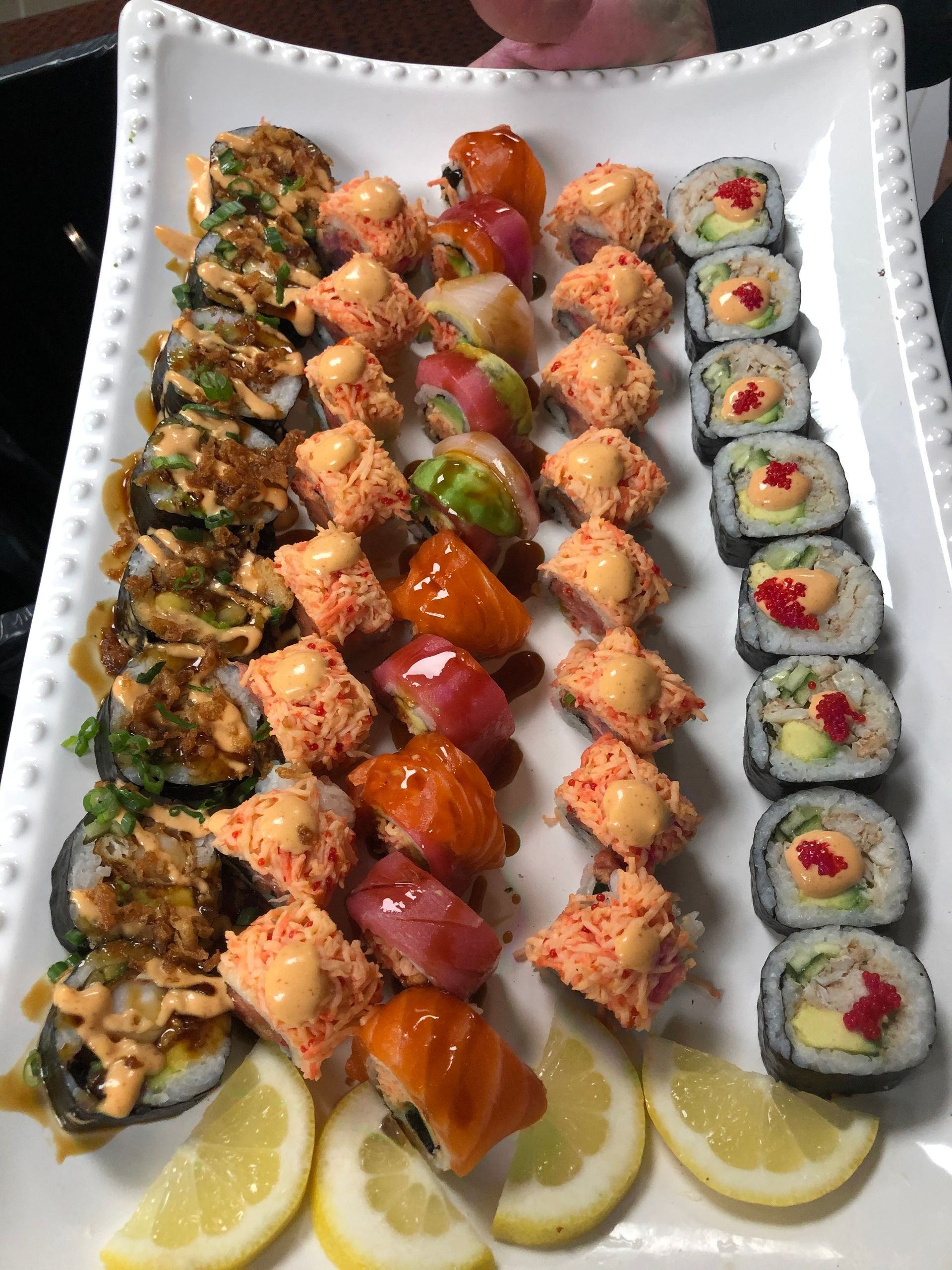 Chef garnishes a plated dish of food, focusing on arrangement.