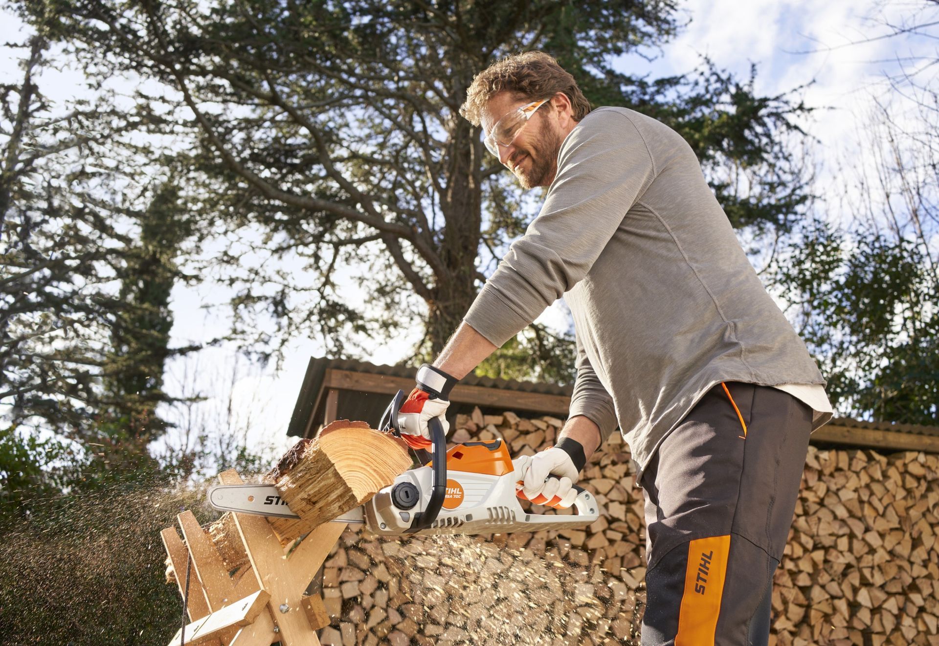 Homme coupant du bois avec une tronçonneuse Stihl 