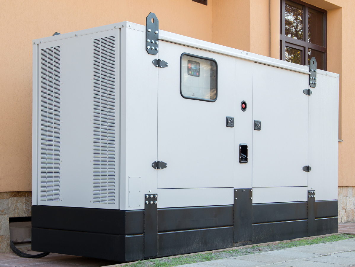 White and black generator outside a building.