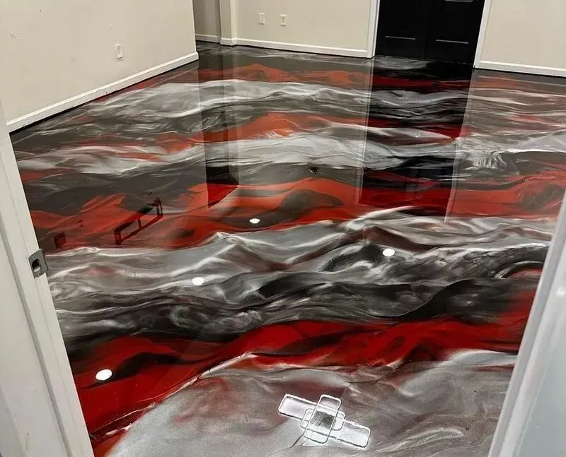 Custom red, black, and silver metallic epoxy floor design.