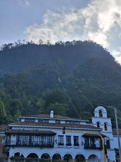 Edificio con entrada arqueada, banderas y gente haciendo cola.