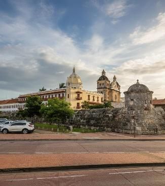 Edificios históricos en Cartagena, Colombia. Arquitectura color crema con estructuras abovedadas, muros de piedra y cielo azul.