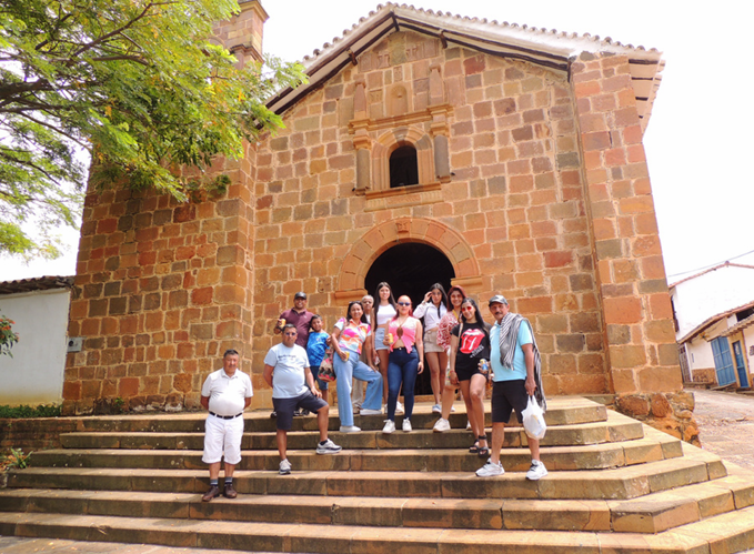 Grupo de personas de pie en los escalones de una iglesia de piedra.