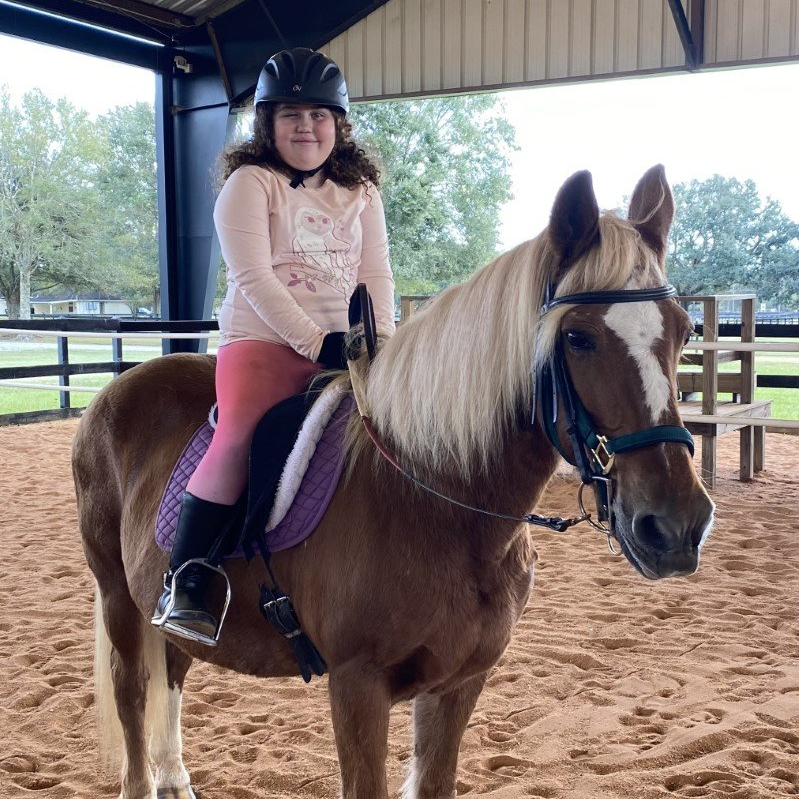 Child with special needs on her horse.
