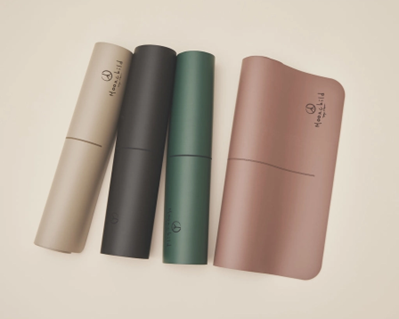 Four different colored yoga mats are stacked on top of each other