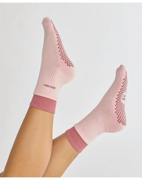 A woman wearing green and white socks is sitting on the floor