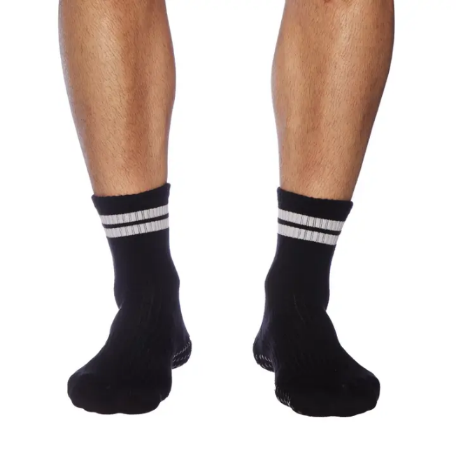 A pair of black socks with white stripes on the bottom