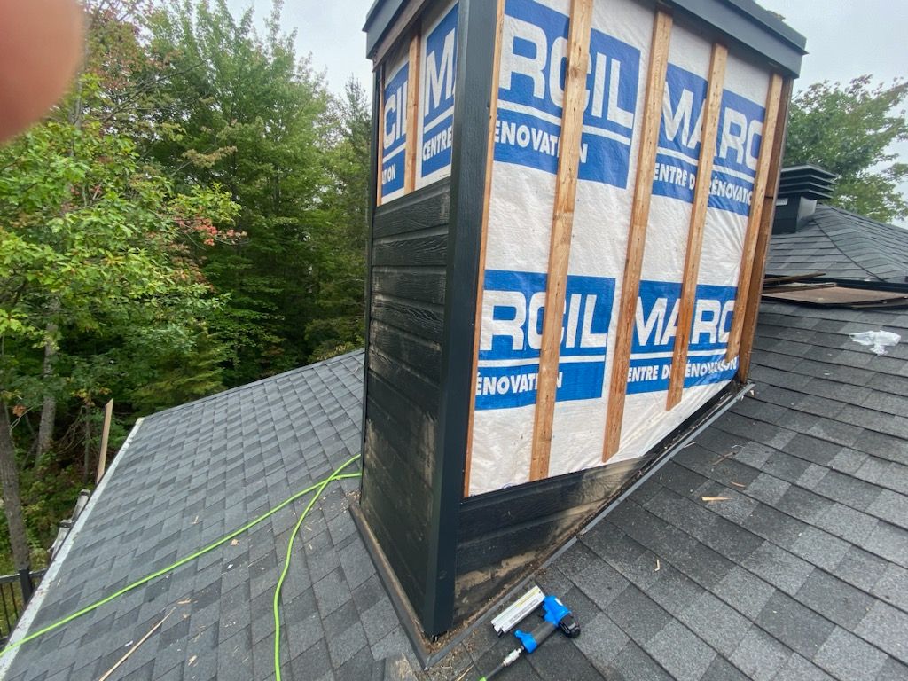 Une cheminée est en cours d'installation sur le toit d'une maison.