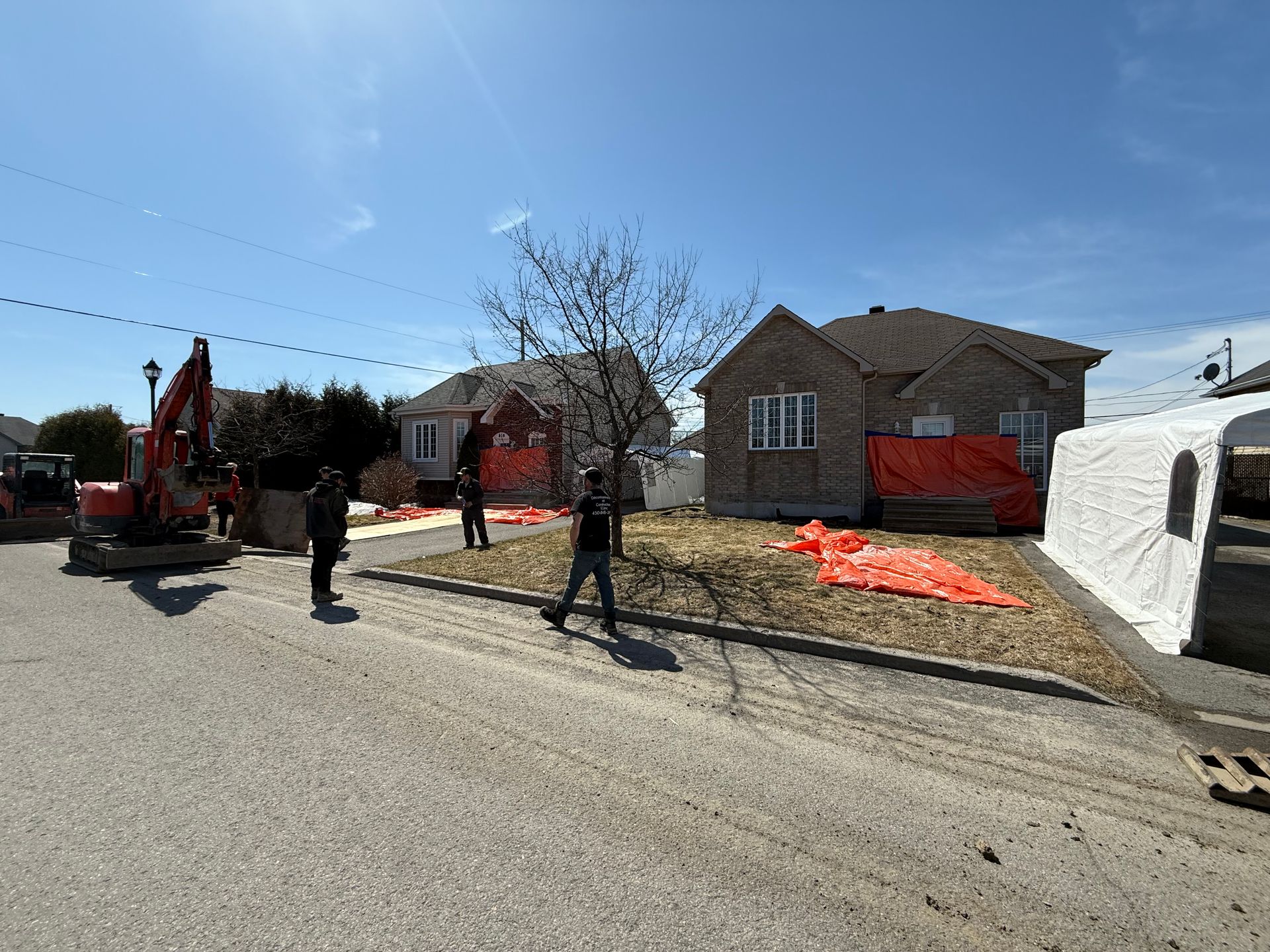 Un groupe de personnes marche dans une rue devant une maison.