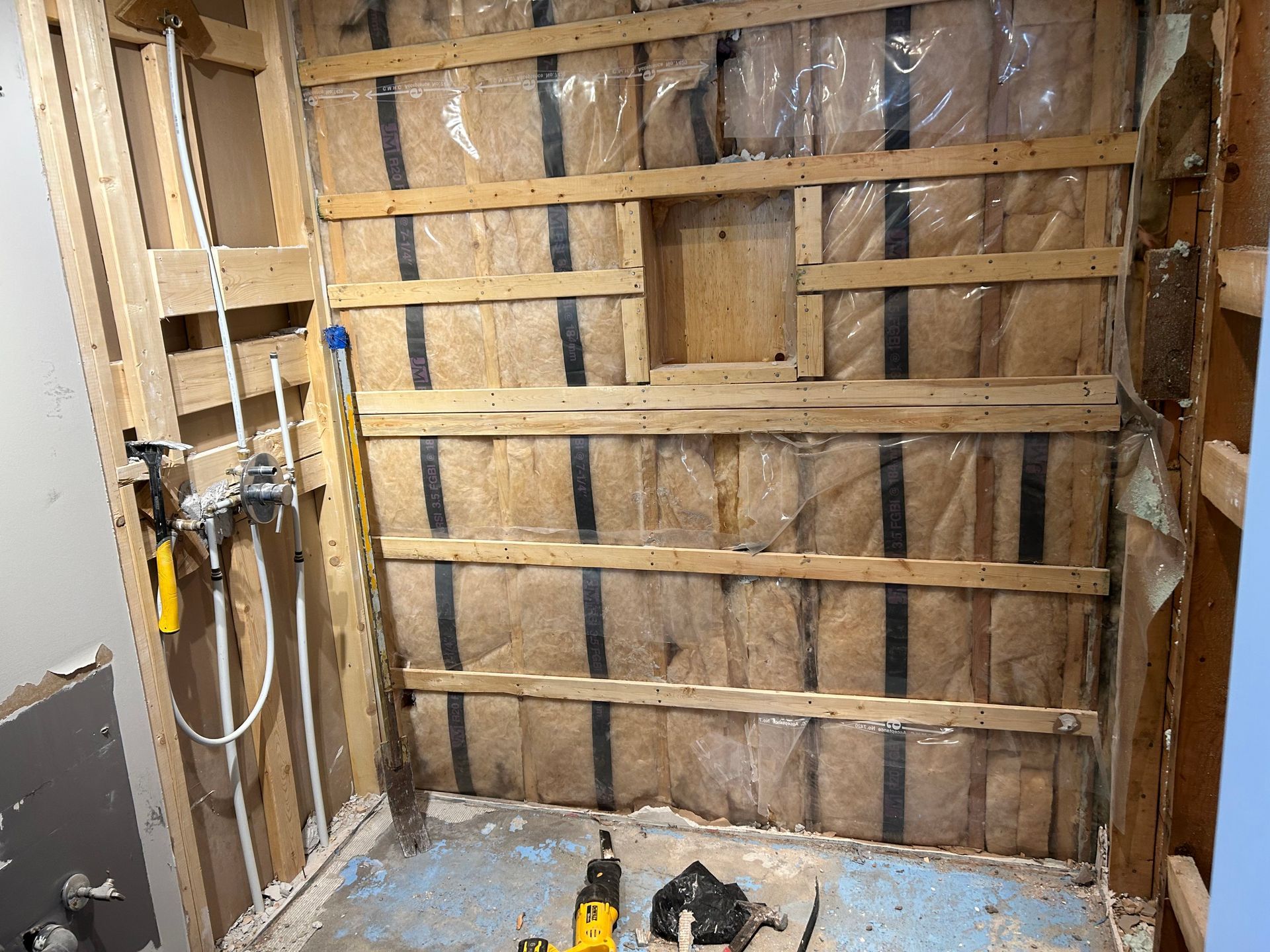Une salle de bain en construction avec une perceuse au sol.