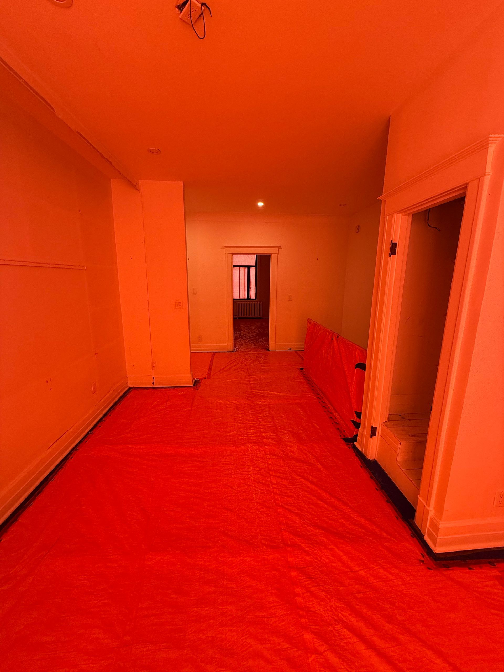 Une pièce vide avec un tapis rouge sur le sol.
