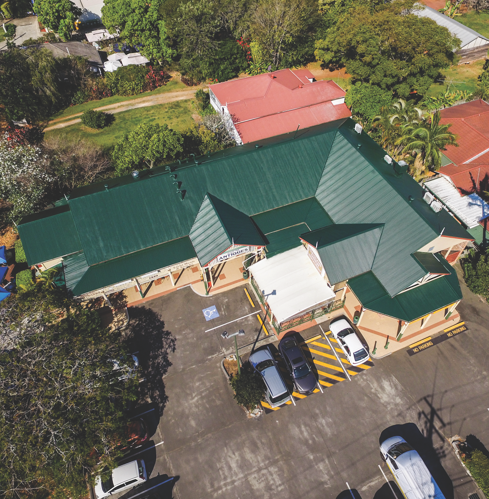 Aerial view of a house with a red roof and rooftop solar panels.