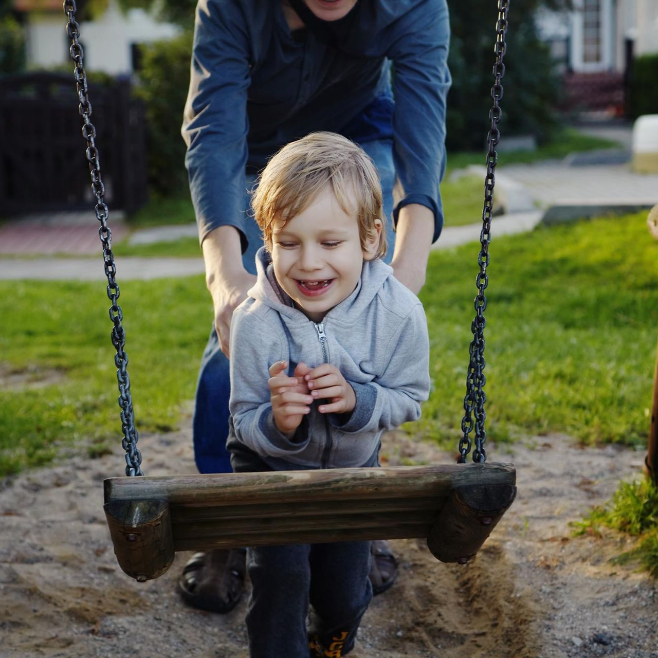 A man and a woman are holding a baby on their shoulders.