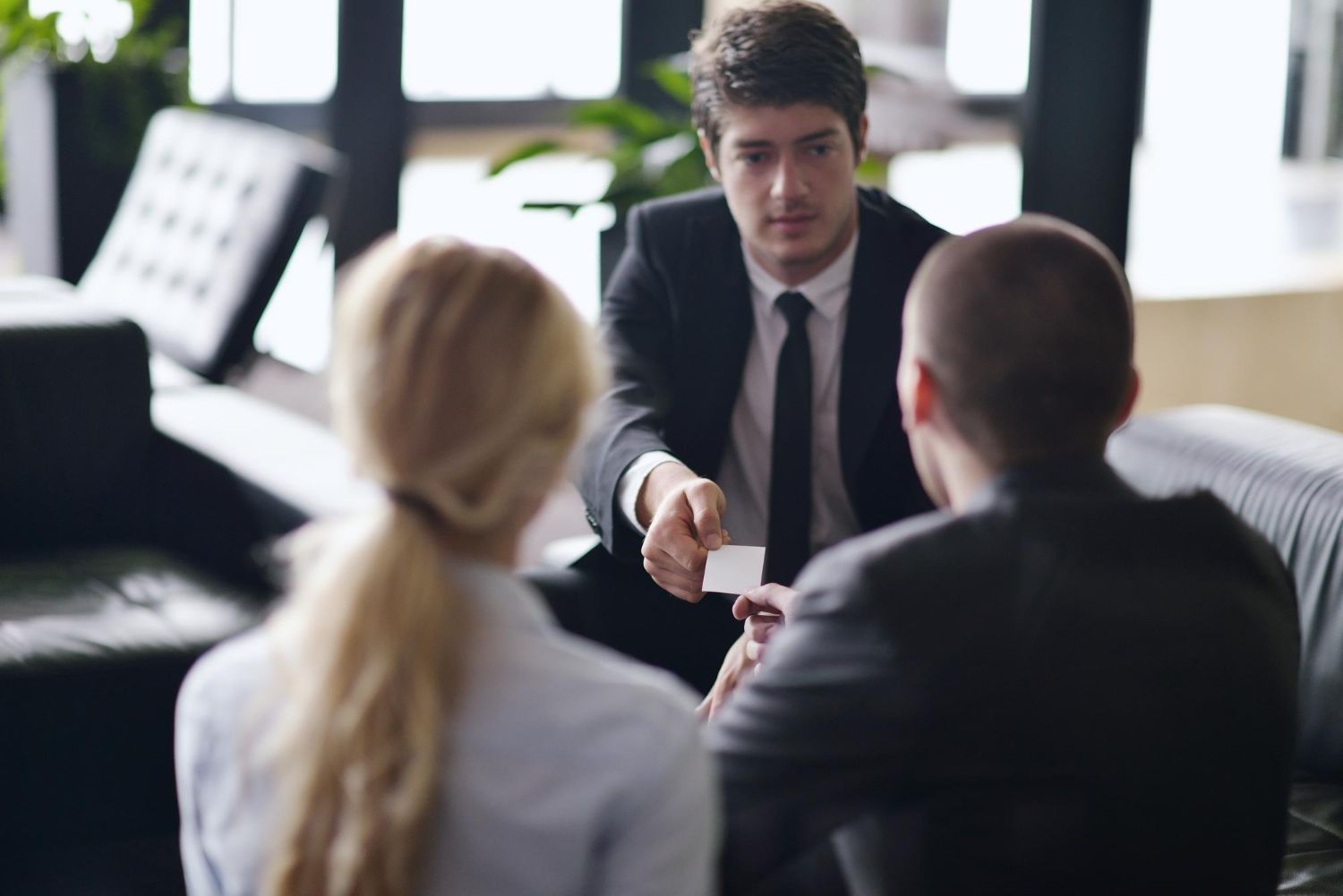 A man and a woman are holding a baby on their shoulders.