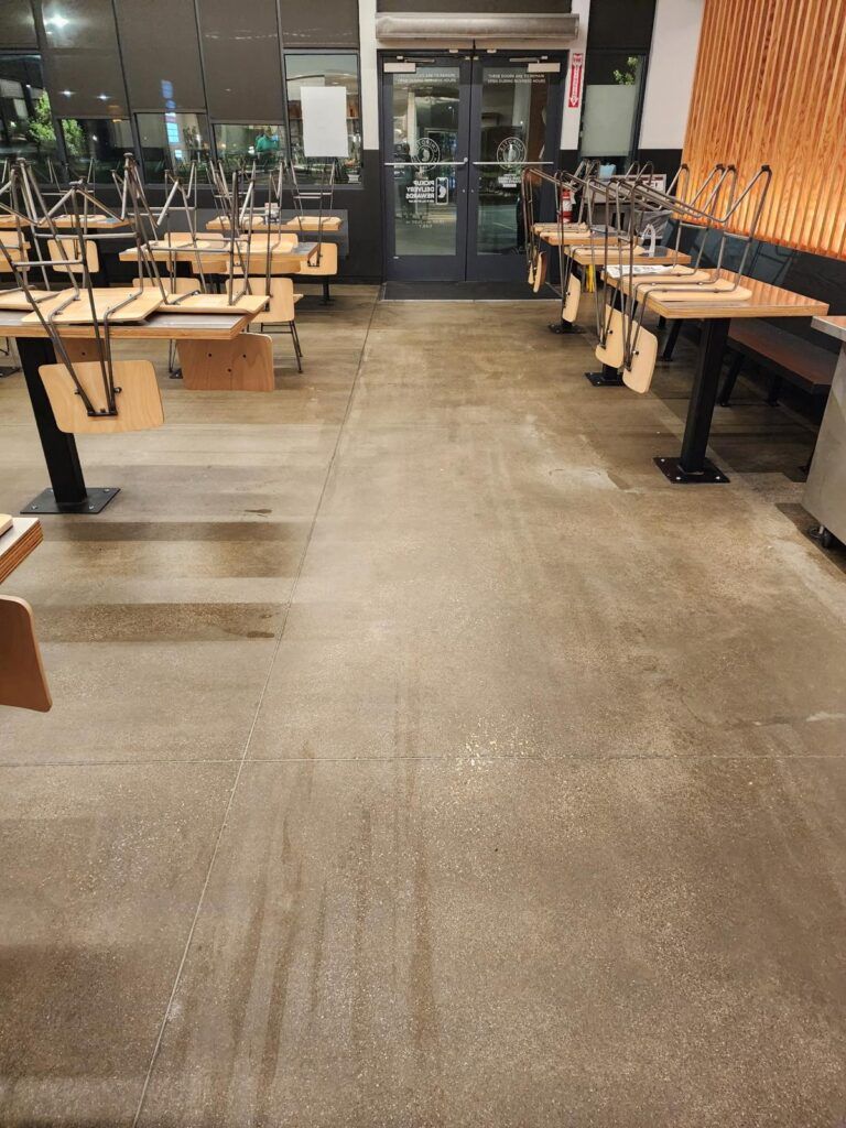 Restaurant interior with tables, chairs, and entry door. Chairs are placed upside down on tables.