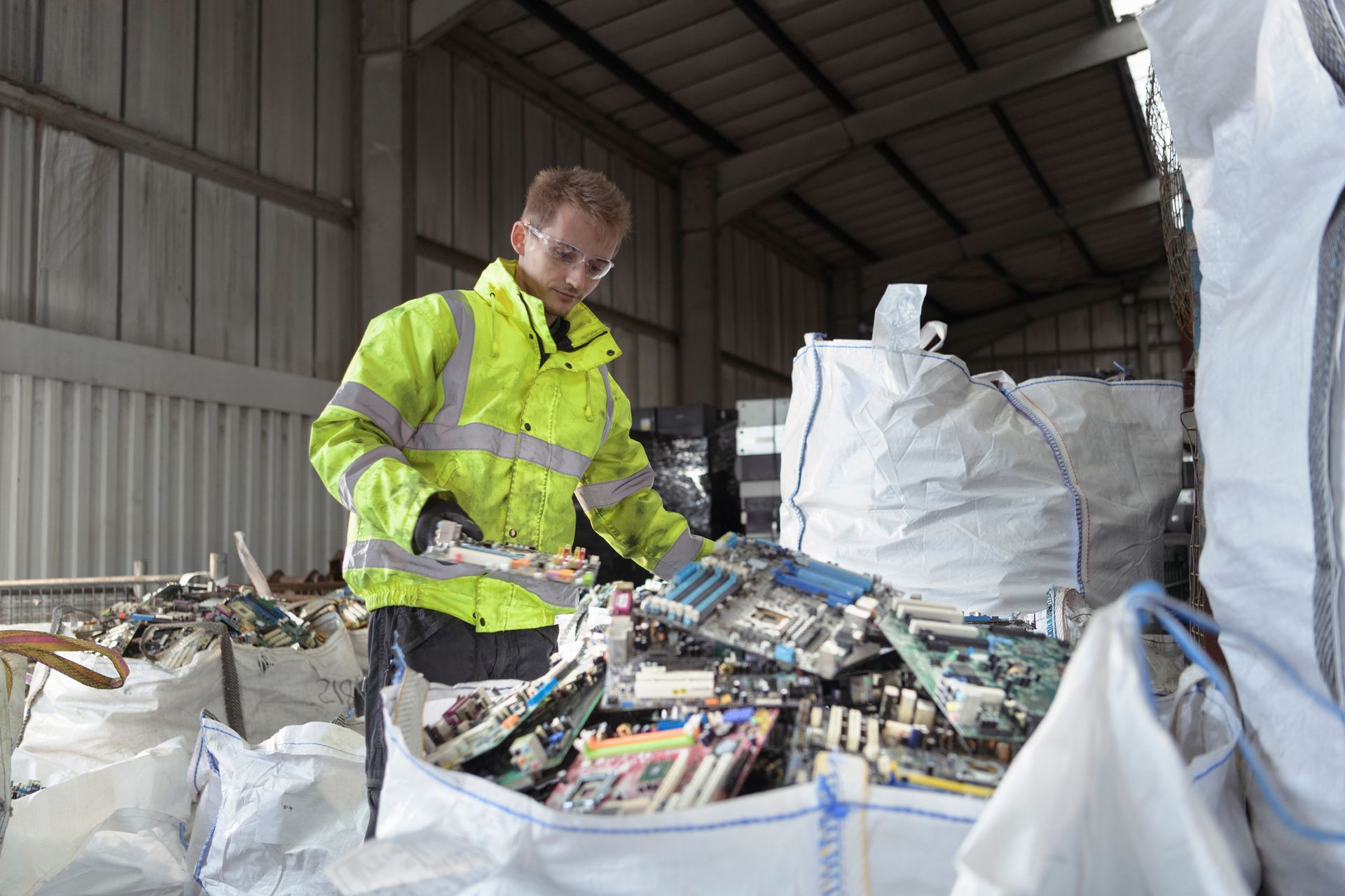 Worker in high-visibility jacket sorting electronic waste for ITAD solutions in Columbia, MO at Didi