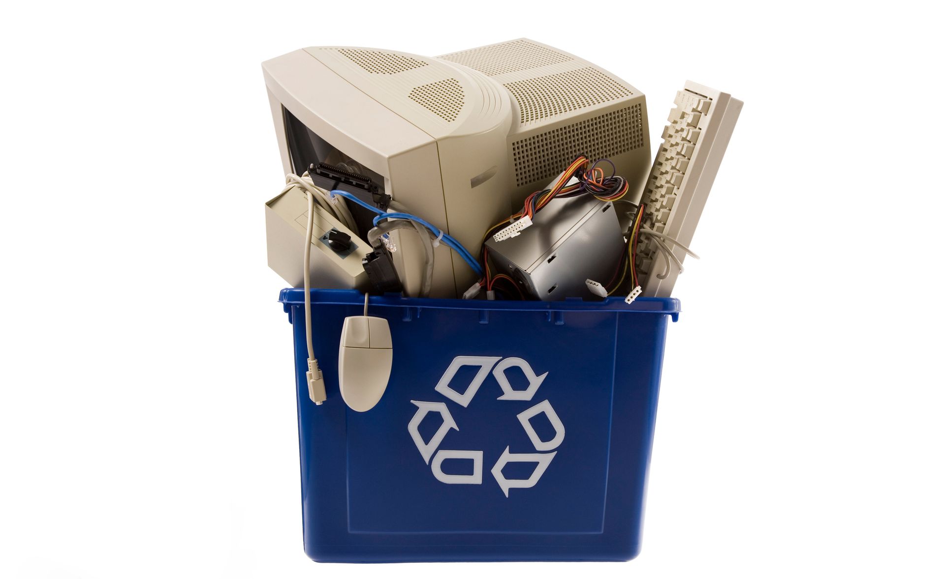 Blue recycling bin filled with old computer parts, including a monitor, keyboard, and mouse.
