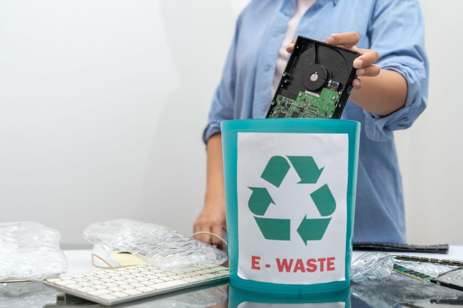 A woman separating e-waste, or electronic waste, for recycling. A woman separating e-waste, or electronic waste, for recycling.