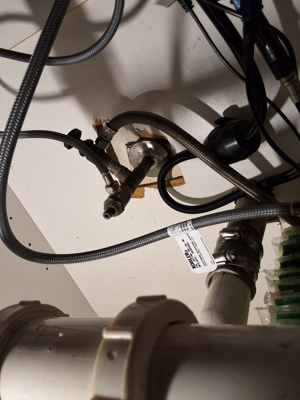 Coiled cables and plugs tangled around a small device on a white surface.