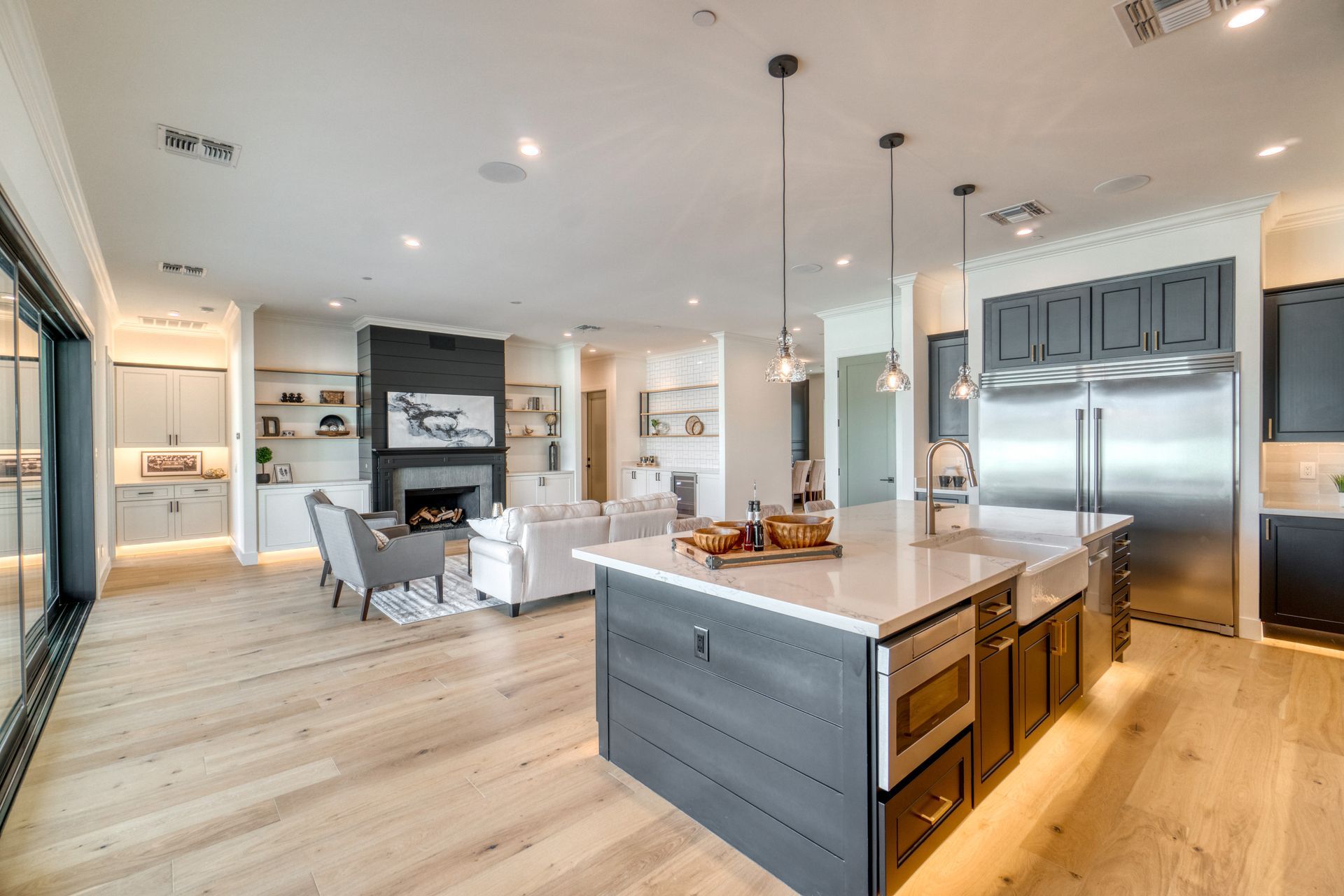 Bright modern kitchen with island, stainless steel appliances, and open living area