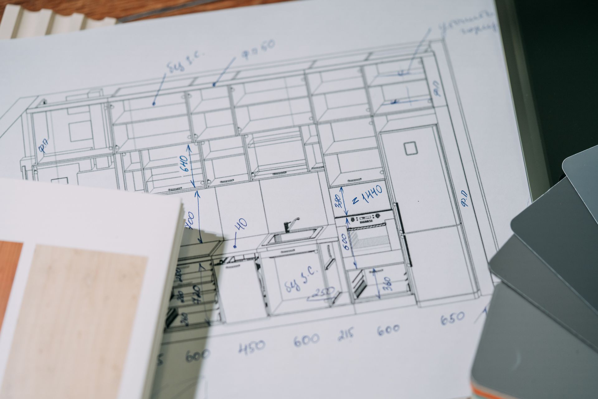 Architectural floor plan sketches on paper with a ruler and color swatches nearby