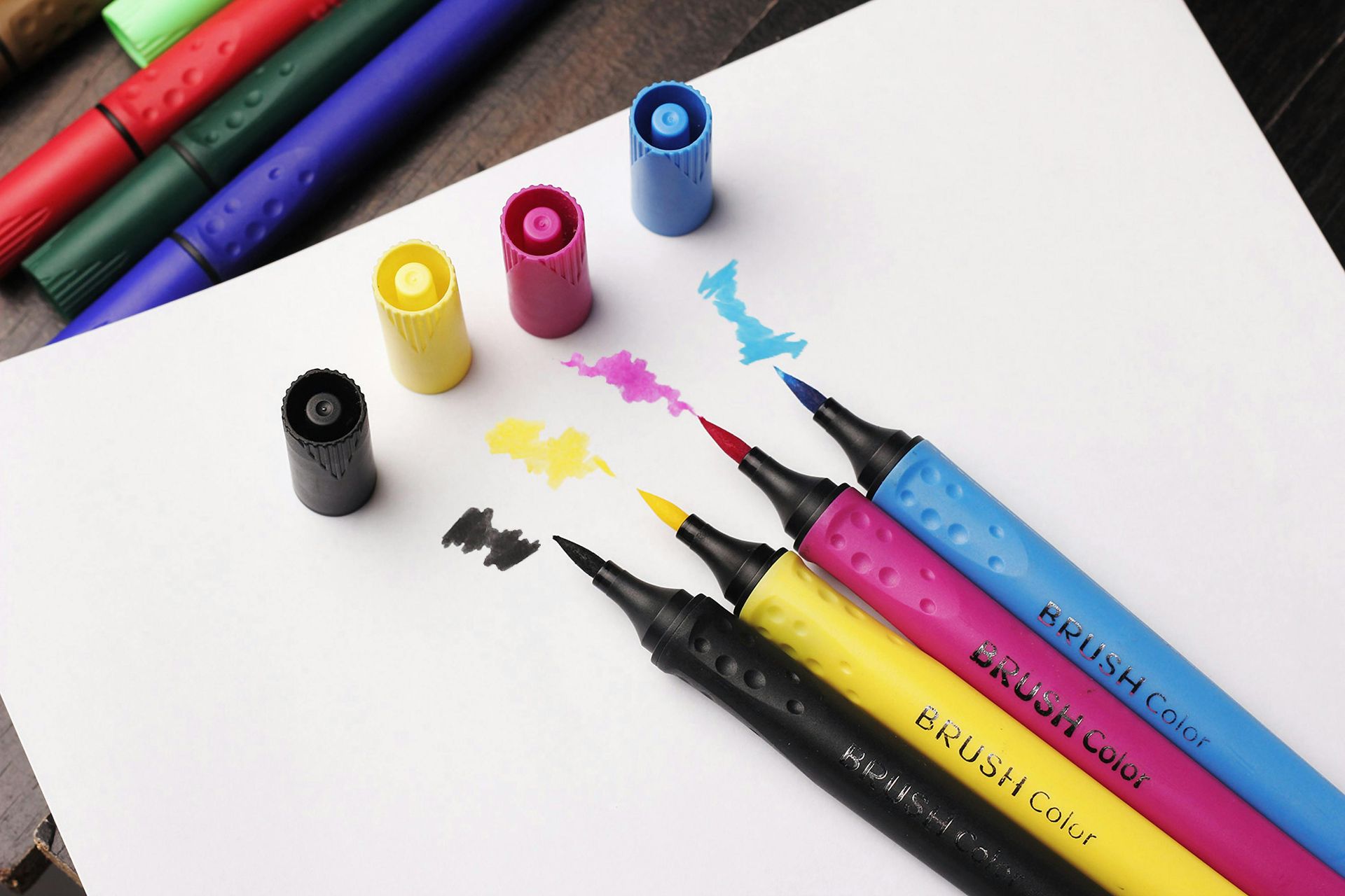 A bunch of different colored markers on a piece of paper