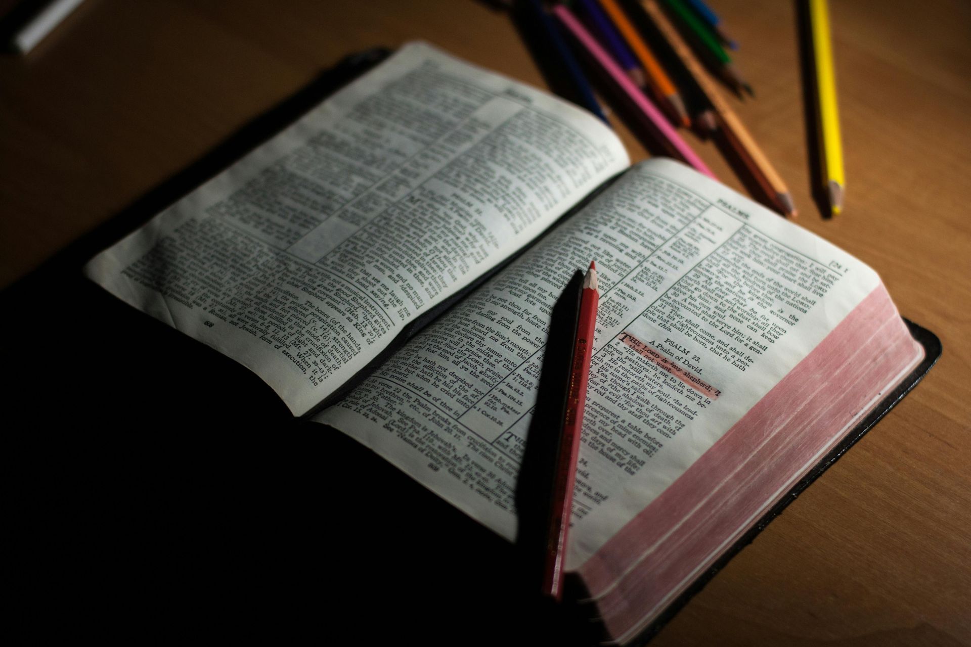 An open bible with a pencil on top of it