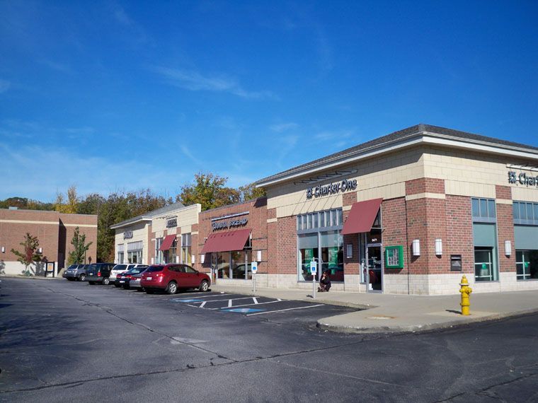A parking lot with cars parked in front of a brick building.