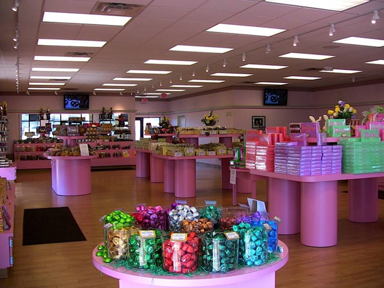A candy store with lots of pink tables and displays