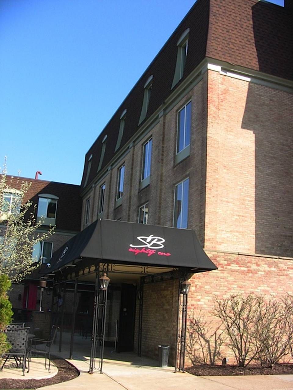 A brick building with a black awning that says sb on it