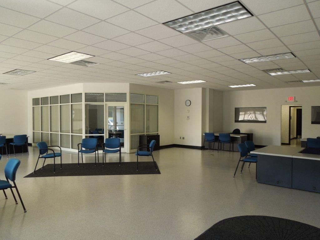 A large room with blue chairs and a clock on the wall