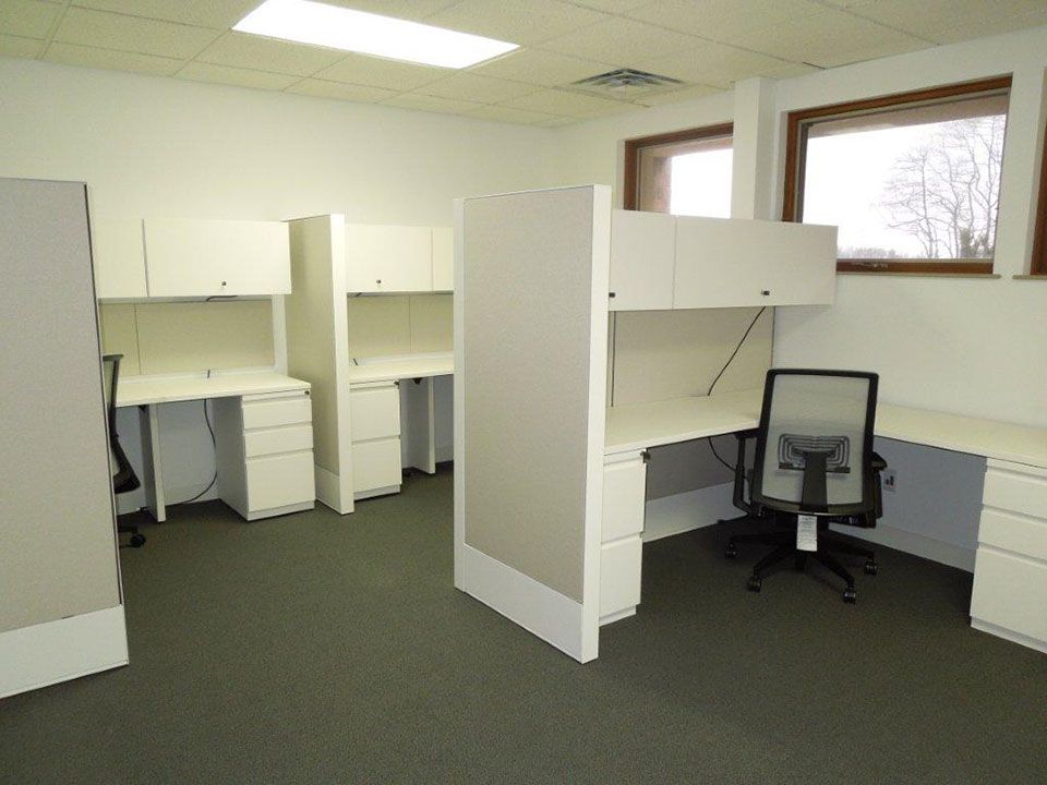 A room with cubicles and a chair in it