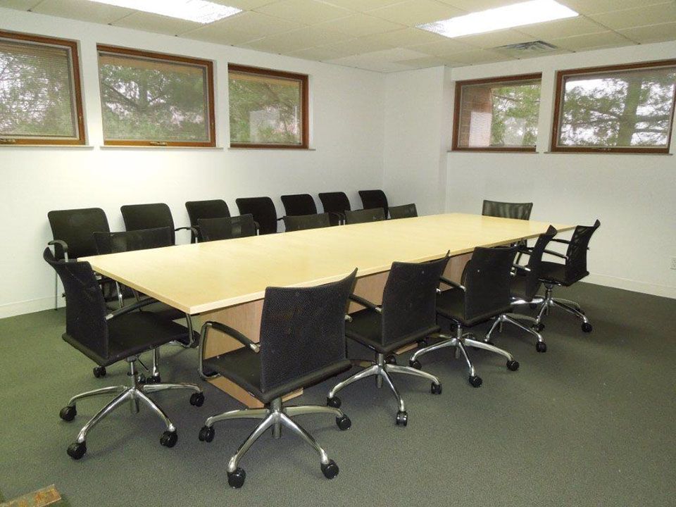 A conference room with a long table and chairs