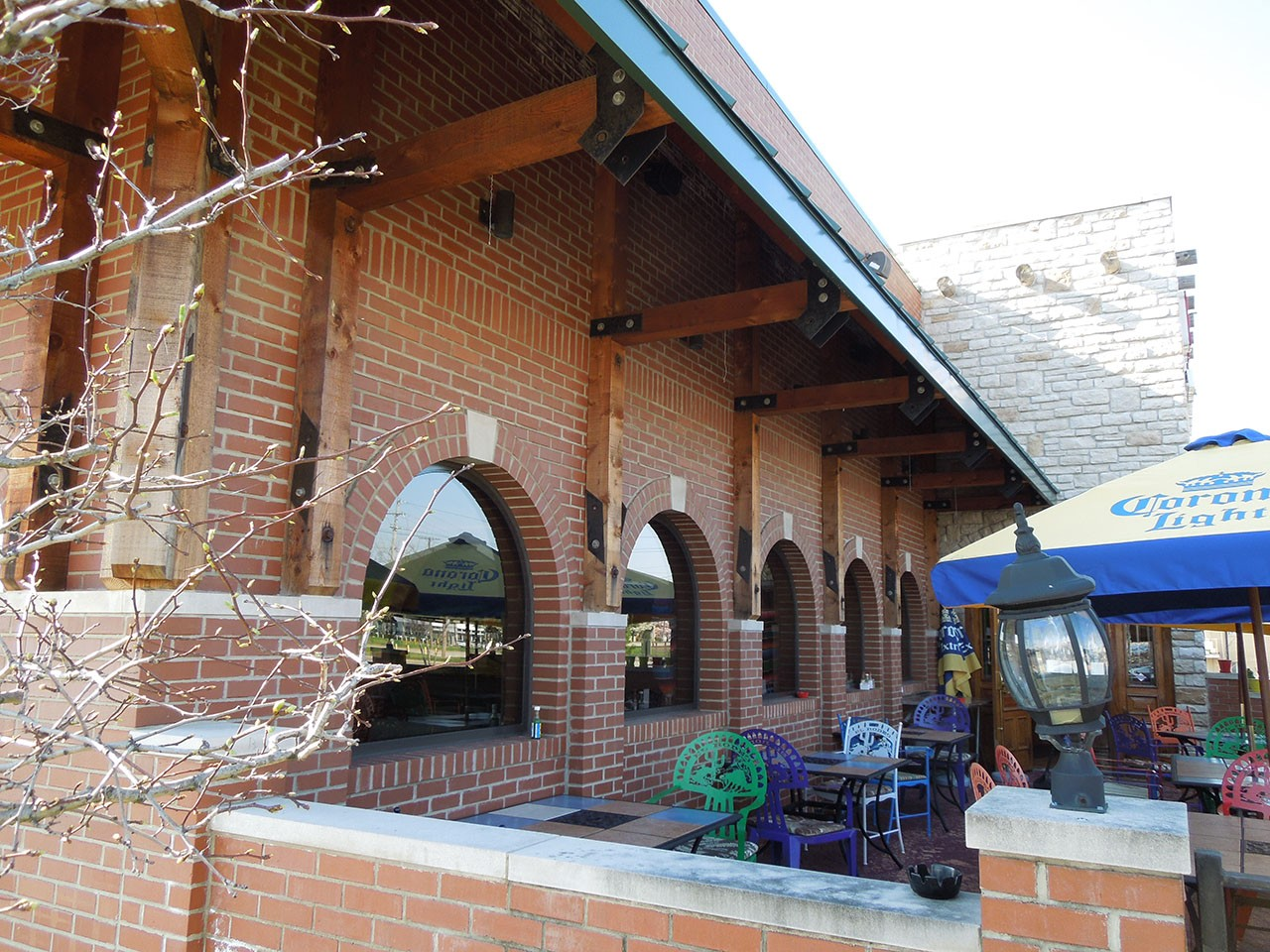 A brick building with a blue umbrella that says corona