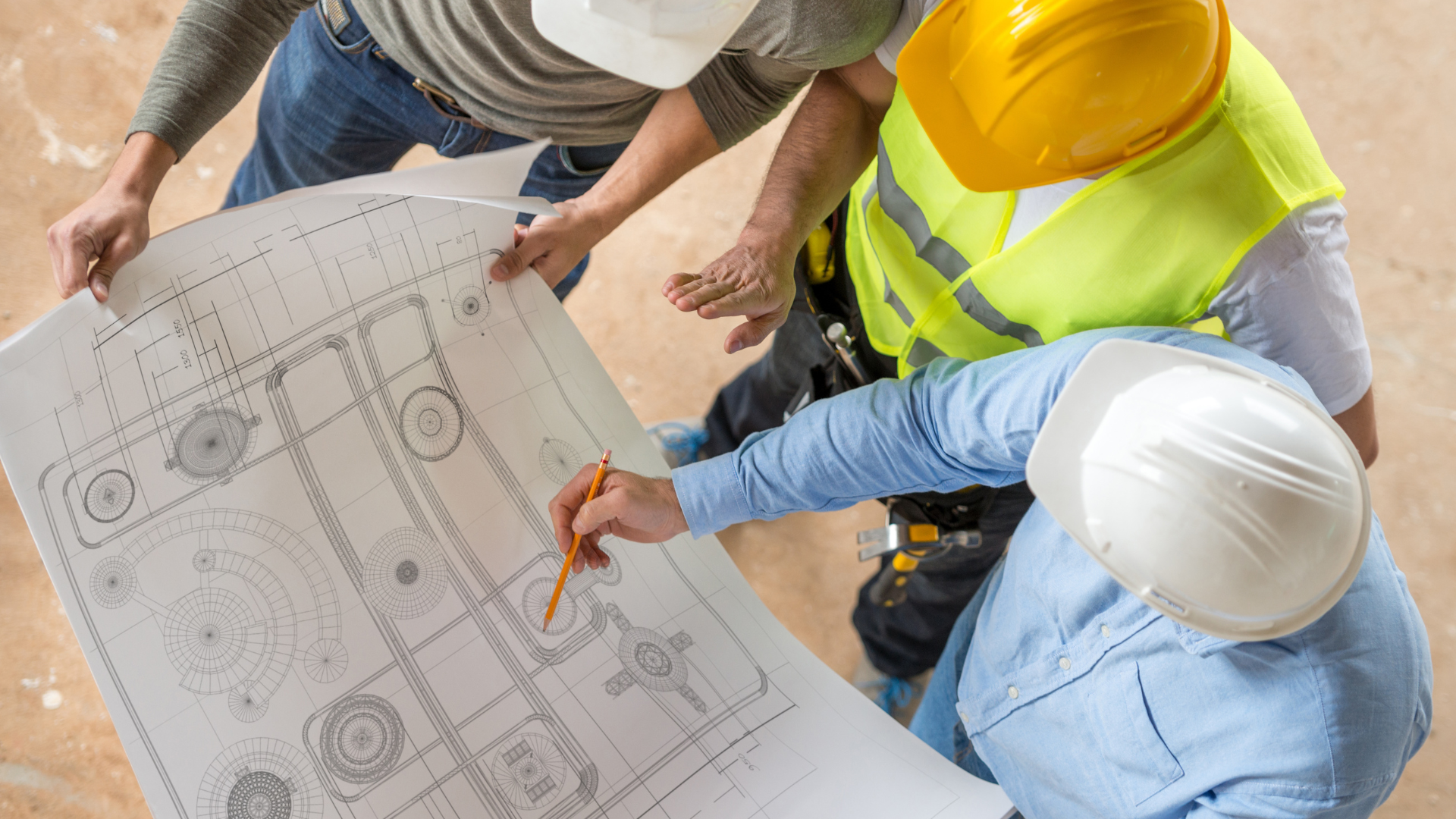 A group of construction workers are looking at a blueprint.