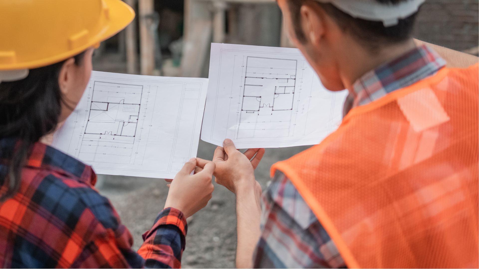 A man and a woman are looking at a blueprint on a construction site.