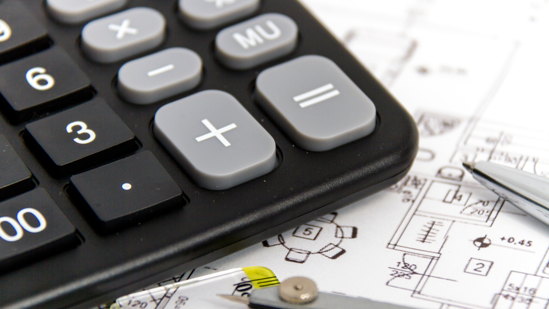 A calculator is sitting on top of a piece of paper next to a pen.
