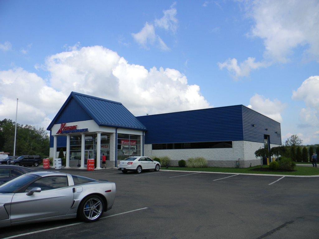 A silver car is parked in front of a store