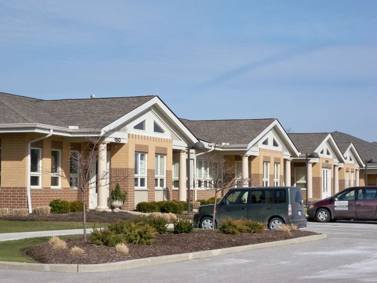 A row of houses with cars parked in front of them