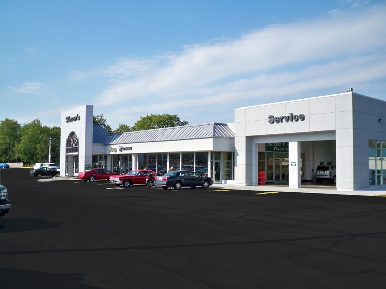Cars are parked in front of a service building