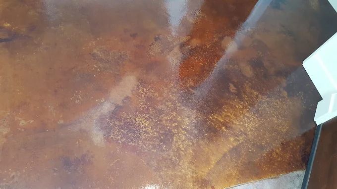 Brown and gold stained concrete floor with a glossy finish.