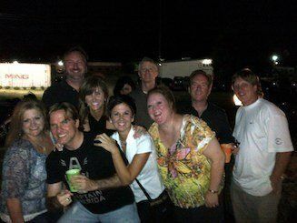 A group of people are posing for a picture together at night.