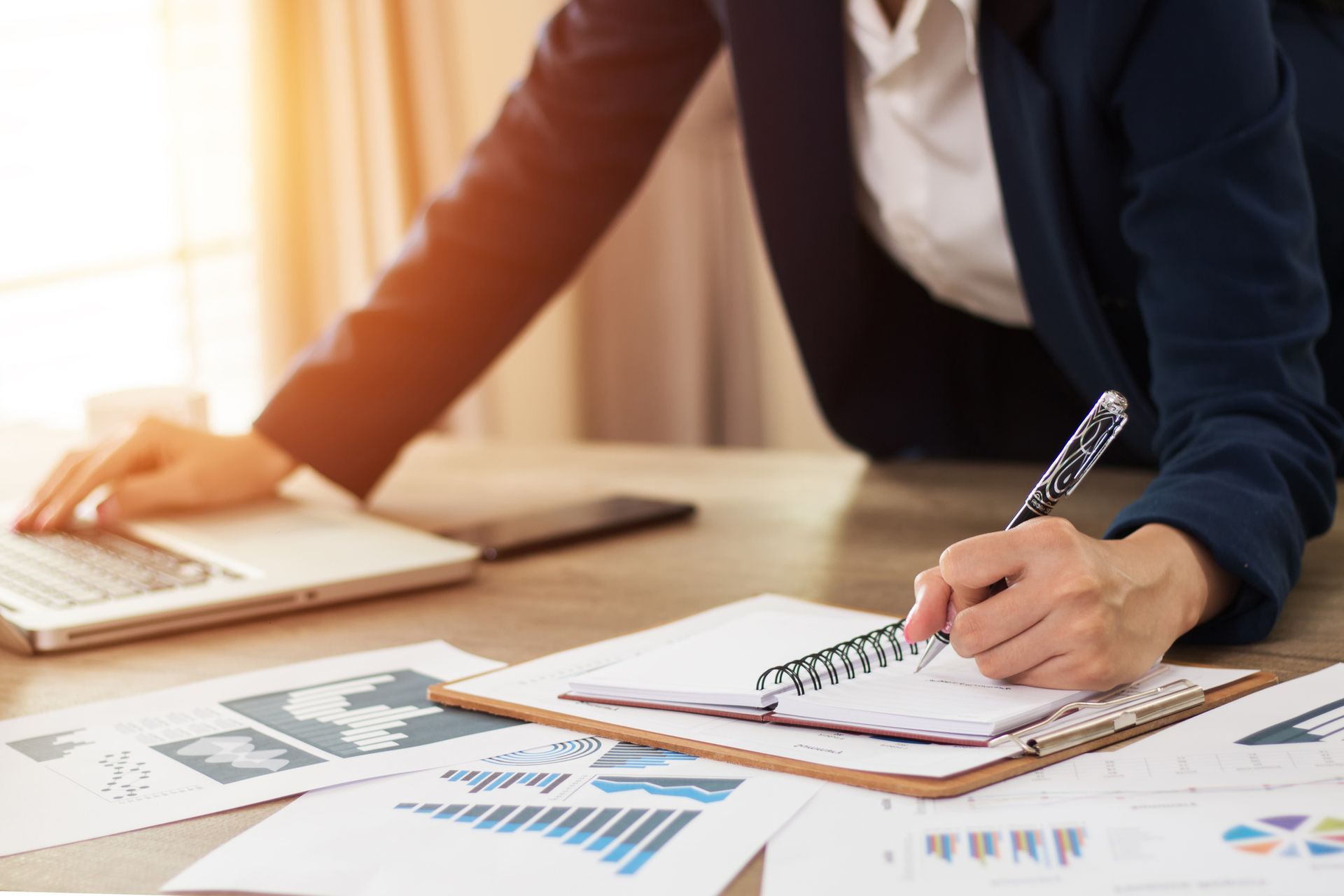 A person writing on a notebook | Commercial Business Broker Memphis TN | Tax Force