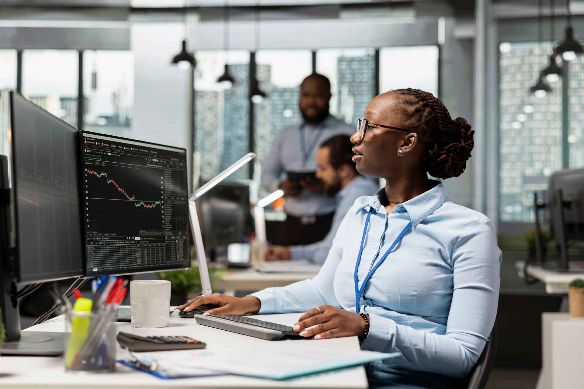 A broker in a brokerage firm office analyzing market metrics and executing trades on a computer A broker in a brokerage firm office analyzing market metrics and executing trades on a computer